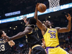 Lakers' Dwight Howard, right, grabs a rebound from Raptors' Pascal Siakam, centre, during first half NBA action at Scotiabank Arena in Toronto, Friday, March 18, 2022.
