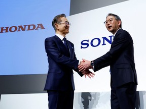Sony Corp's Chief Executive Kenichiro Yoshida shakes hands with Honda Motor's Toshihiro Mibe as they attend a joint news conference at Sony's headquarters in Tokyo, March 4, 2022.
