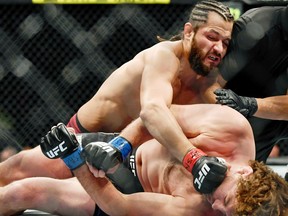 Jorge Masvidal (red gloves) punches Ben Askren (blue gloves) as referee Jason Herzog stops the fight at T-Mobile Arena in Las Vegas, July 6, 2019.