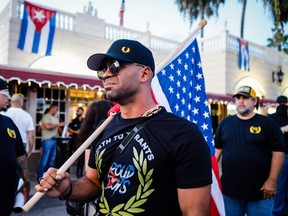 In this file photo taken on July 16, 2021, Henry "Enrique" Tarrio, leader of The Proud Boys, holds an American flag during a protest showing support for Cubans demonstrating against their government in Miami, Fla.