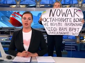 Eine Frau hat am Montag das Nachrichtenset des staatlichen russischen Fernsehkanals Eins zum Absturz gebracht und ein Schild mit der Aufschrift gezeigt "Kein Krieg".