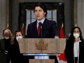 Prime Minister Justin Trudeau, with Minister of Foreign Affairs Melanie Joly, Deputy Prime Minister and Minister of Finance Chrystia Freeland, and Minister of National Defence Anita Anand, attends a news conference in Ottawa Feb. 24, 2022.