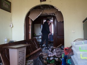Ein Verwandter hilft bei der Reinigung der Wohnung von Olena Zaichenko, die am 18. März 2022 in Kiew, Ukraine, durch einen Raketenangriff auf das Wohngebiet zerstört wurde.