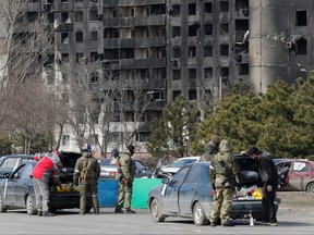 Militärangehörige pro-russischer Truppen kontrollieren Autos während des Konflikts zwischen der Ukraine und Russland in der belagerten südlichen Hafenstadt Mariupol, Ukraine, 20. März 2022.