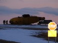 Emergency crews work around the wreckage of a downed CH-149 Cormorant search and rescue helicopter at 9 Wing Canadian Forces Base Gander, in Gander, N.L., Thursday, March 10, 2022.