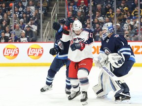 Winnipeg Jets defenceman Nate Schmidt (88) jostles for position with Columbus Blue Jackets forward Justin Danforth (17) in front of Winnipeg Jets goalie Eric Comrie (1) during the first period at Canada Life Centre in Winnipeg on Friday, March 25, 2022.