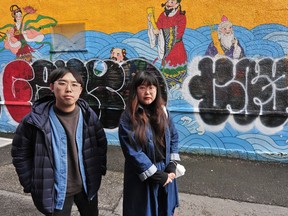 Artists Sean Cao and Katharine Yi in front of their mural which was vandalized in Chinatown.
