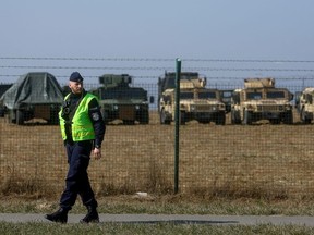 A police officer walks outside Rzeszow-Jasionka Airport as U.S. military equipment is seen inside, ahead of U.S. President Joe Biden's planned arrival to visit Poland amid Russia's invasion of Ukraine, near Rzeszow, Poland, March 25, 2022.