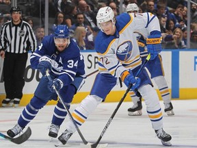Tage Thompson of the Buffalo Sabres skates with the puck against Auston Matthews of the Toronto Maple Leafs during an NHL game at Scotiabank Arena on April 12, 2022 in Toronto, Ontario, Canada.