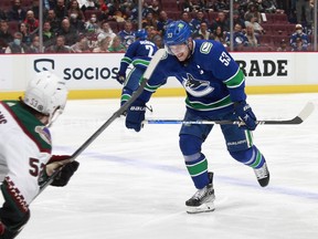 Michael Carcone of the Arizona Coyotes looks on as Bo Horvat of the Vancouver Canucks winces while skating to the bench after getting hit in the ankle with the puck during their NHL game at Rogers Arena Thursday. Vancouver won 7-1.