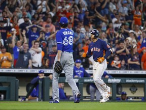 Toronto Blue Jays closer Jordan Romano walks off the field as Astros' Jeremy Pena rounds third after hitting a walk-off home run during the 10th inning at Minute Maid Park on Sunday.
