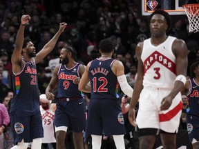 Toronto Raptors forward OG Anunoby (3) looks on as Philadelphia 76ers centre Joel Embiid (21) reacts after defeating the Raptors during overtime NBA round one basketball playoff action in Toronto on Wednesday, April 20, 2022.