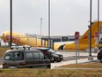 Airport personnel stand at the scene where a Boeing 757-200 cargo aircraft operated by DHL made an emergency landing before skidding off the runway and splitting, aviation authorities said, at the Juan Santamaria International Airport in Alajuela, Costa Rica, April 7, 2022.