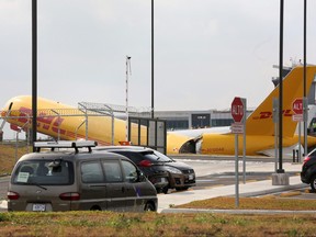 Flughafenpersonal steht an der Stelle, an der ein von DHL betriebenes Frachtflugzeug vom Typ Boeing 757-200 eine Notlandung durchführte, bevor es von der Landebahn rutschte und sich aufteilte, teilten die Luftfahrtbehörden mit, am 7. April 2022 auf dem internationalen Flughafen Juan Santamaria in Alajuela, Costa Rica.