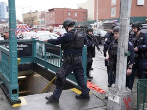 Members of the New York Police Department and emergency vehicles crowd the streets near a subway station in New York City on April 12, 2022.