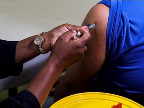 A healthcare worker administers the Pfizer COVID-19 vaccine to a man, amidst the spread of the SARS-CoV-2 variant Omicron, in Johannesburg, South Africa, Dec. 9, 2021.