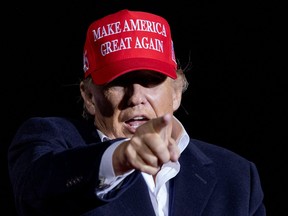 Former U.S. President Donald Trump points as he holds a rally in Florence, Arizona January 15, 2022.