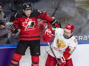 Canada's Ryan O’Rourke, left, is checked by Russia's Matvey Michkov during a world junior game in Edmonton in December. THE CANADIAN PRESS FILES