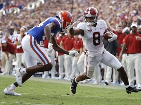 Sep 18, 2021; Gainesville, Florida, USA; Alabama Crimson Tide wide receiver John Metchie III (8) runs with the ball as Florida Gators cornerback Avery Helm (24) defends during the second half at Ben Hill Griffin Stadium.