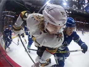 Vegas Golden Knights' William Karlsson (71) and Vancouver Canucks' William Lockwood (58) vie for the puck during the first period of an NHL hockey game in Vancouver, B.C., Sunday, April 3, 2022.