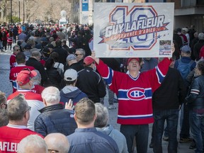 Louis Theberge, a fan of Guy Lafleur, displays a sign as he waits along Canadiens-de-Montréal Ave. on Sunday May 1, 2022, prior to the opening of the Bell Centre, where Lafleur's body was lying in state.