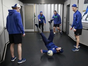 Conor Garlandof the Vancouver Canucks falls to the ground as he kicks a soccer ball before their NHL game against the Arizona Coyotes at Rogers Arena April 14, 2022.