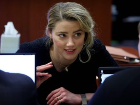 Amber Heard speaks to her legal team during the Depp vs Heard defamation trial in Fairfax, Va., April 28, 2022.