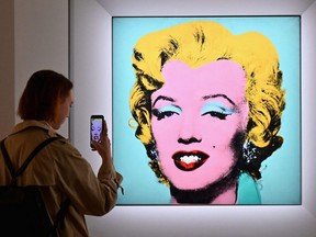 Eine Frau macht ein Foto von Andy Warhols 'Shot Sage Blue Marilyn' während der Pressevorschau von Christie's 20th and 21st Century Art bei Christie's New York in New York City, 29. April 2022.