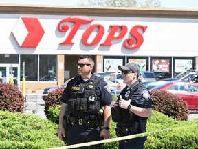 Police stand in front of a Tops Grocery store in Buffalo, New York, on May 15, 2022. (Photo by USMAN KHAN/AFP via Getty Images)