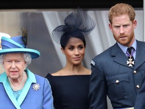 Königin Elizabeth II., Prinz Harry, Herzog von Sussex und Meghan, Herzogin von Sussex auf dem Balkon des Buckingham Palace, während die königliche Familie am 10. Juli 2018 in London, England, an Veranstaltungen zum 100. Jahrestag der RAF teilnimmt.