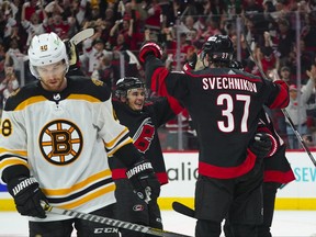Carolina Hurricanes right wing Andrei Svechnikov (37) is congratulated by center Sebastian Aho (20) and centre Seth Jarvis (24) after his empty net goal against the Boston Bruins during the third period in game one of the first round of the 2022 Stanley Cup Playoffs at PNC Arena in Raleigh, N.C., May 2, 2022.