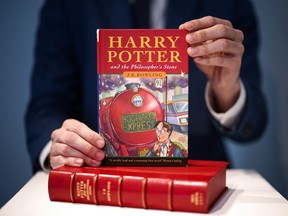 A person holds a rare first edition and signed by the author copy of 'Harry Potter and the Philosophers Stone' by J.K. Rowling, which is to be put up for auction at Christie's auction house in London May 31, 2022.