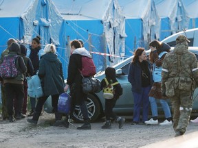 Während des Ukraine-Russland-Konflikts in der Region Donezk gehen Zivilisten, die aus dem Stahlwerk Azovstal in Mariupol evakuiert wurden, in Begleitung eines Mitglieds des Internationalen Komitees des Roten Kreuzes und eines UN-Mitarbeiters zu Fuß in eine provisorische Unterkunft im Dorf Bezimenne , Ukraine, Freitag, 6. Mai 2022.