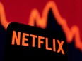 A smartphone with Netflix logo is seen in front of a descending stock graph in this illustration taken on April 19, 2022.