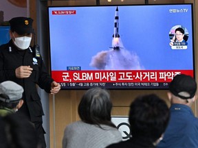 People watch a TV screen showing a news broadcast with file footage of a North Korean missile test, at a railway station in Seoul, Saturday, May 7, 2022, after North Korea fired a submarine-launched ballistic missile according to South Korea's military.