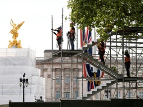 Arbeiter errichten vor den geplanten Feierlichkeiten zum Platinjubiläum von Queen Elizabeth am 6. Mai 2022 in London provisorische Strukturen rund um den Buckingham Palace.