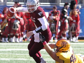 Ottawa Gee-Gees quarterback Sawyer Buettner escapes the grasp Queen's Golden Gaels Cameron Lawson at Richardson Stadium on Saturday, October 20 2018. The Bombers have acquired Lawson from the Als. Ian MacAlpine/Postmedia Network file