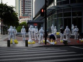 Arbeiter in Schutzanzügen versammeln sich während des Lockdowns inmitten des COVID-19-Ausbruchs in Shanghai, China, am Mittwoch, den 25. Mai 2022.