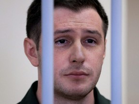 U.S. ex-Marine Trevor Reed, who was detained in 2019 and accused of assaulting police officers, stands inside a defendants' cage during a court hearing in Moscow, Russia, March 11, 2020.