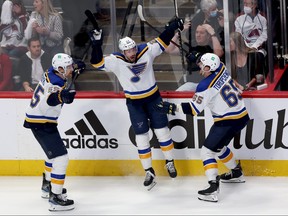 Tyler Bozak (centre) of the St Louis Blues celebrates with Colton Parayko (left) and Alexei Toropchenko after scoring a goal against the Colorado Avalanche in overtime during Game 5 of the Second Round of the 2022 Stanley Cup Playoffs at at Ball Arena on May 25, 2022 in Denver, May 25, 2022.