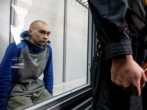 Der russische Soldat Vadim Shishimarin, 21, der verdächtigt wird, gegen die Gesetze und Normen des Krieges verstoßen zu haben, sitzt während einer Gerichtsverhandlung inmitten der russischen Invasion in der Ukraine am 13. Mai 2022 in Kiew, Ukraine, im Käfig eines Angeklagten.