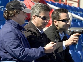 Toronto Blue Jays scouts Tony LaCava (C) and Perry Minasian (L) work the radar gun for General Manager Alex Anthopoulos (R) at the Blue Jays Spring Training stadium in Dunedin Florida.