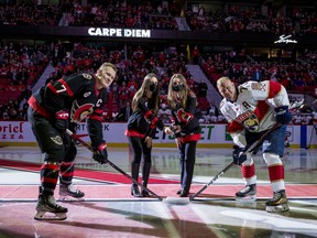Anna, left, and Olivia Melnyk perform a ceremonial faceoff between the Senators' Brady Tkachuk and the Panthers' Patric Hornqvist before a game on April 28.