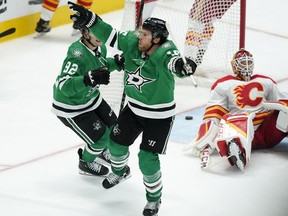 Dallas Stars forwards Joe Pavelski and Vladislav Namestnikov (left) celebrate after Pavelski scored against Calgary Flames goaltender Jacob Markstrom during Game 3 of their first-round playoff series at American Airlines Center in Dallas on Saturday, May 7, 2022.