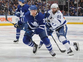 Nikita Kucherov of the Tampa Bay Lightning skates against Justin Holl of the Toronto Maple Leafs during Game 5 of the First Round of the 2022 Stanley Cup Playoffs at Scotiabank Arena on May 10, 2022 in Toronto.