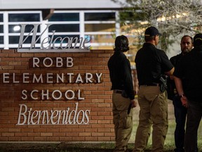 Law enforcement officers speak together outside of Robb Elementary School following the mass shooting at Robb Elementary School on May 24, 2022 in Uvalde, Texas.