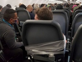 A man sits taped to a seat on a Frontier Airlines flight from Philadelphia to Miami on July 31, 2021, in this picture obtained from social media.