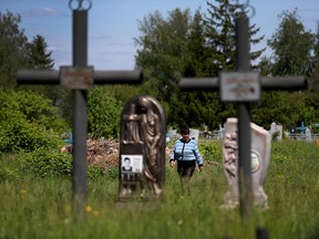 Kateryna Shelikhova, widow of 62-year-old Oleksandr Shelipov, who was shot dead by a Russian soldier who was sentenced to life in prison for killing an unarmed civilian in the first war crimes trial arising from Russia's invasion, walks at the local cemetery to visit her husband's grave in Chupakhivka, Ukraine May 24, 2022.