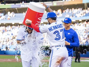 Toronto Blue Jays' Vladimir Guerrero Jr. gets water dumped on him by teammate Teoscar Hernandez.