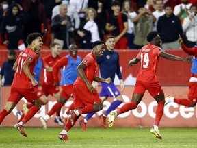 Tajon Buchanan (11) and Jonathan David (20) of Canada celebrate with Alphonso Davies (19) after Davies scored during a World Cup qualifying match against Panama at BMO Field on Oct. 13, 2021, in Toronto.